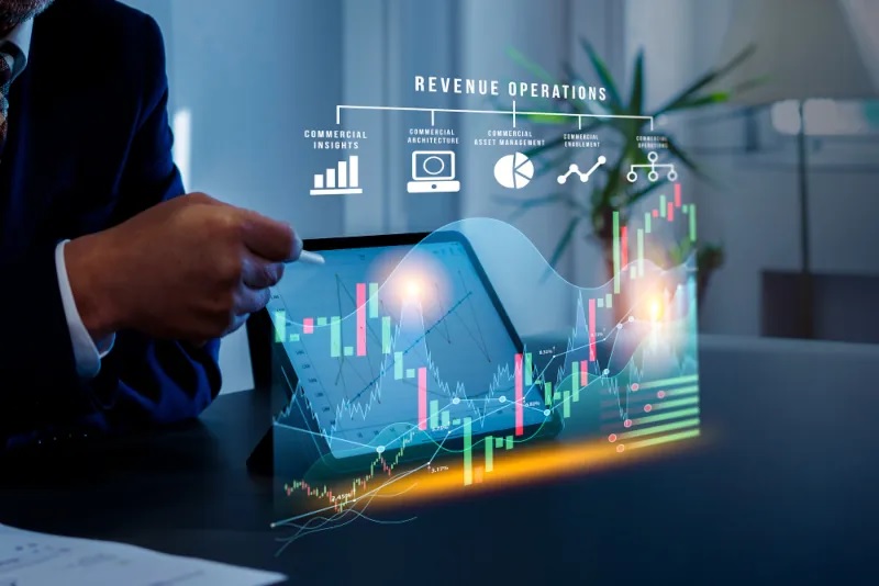 Hand with stylus on a tablet showing holographic revenue operations charts